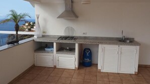 A compact kitchen with a gas stove, sink, and storage cabinets. - Vacation Home "Hibiscus" with Sea View, Pool & Wi-Fi (santa ursula)