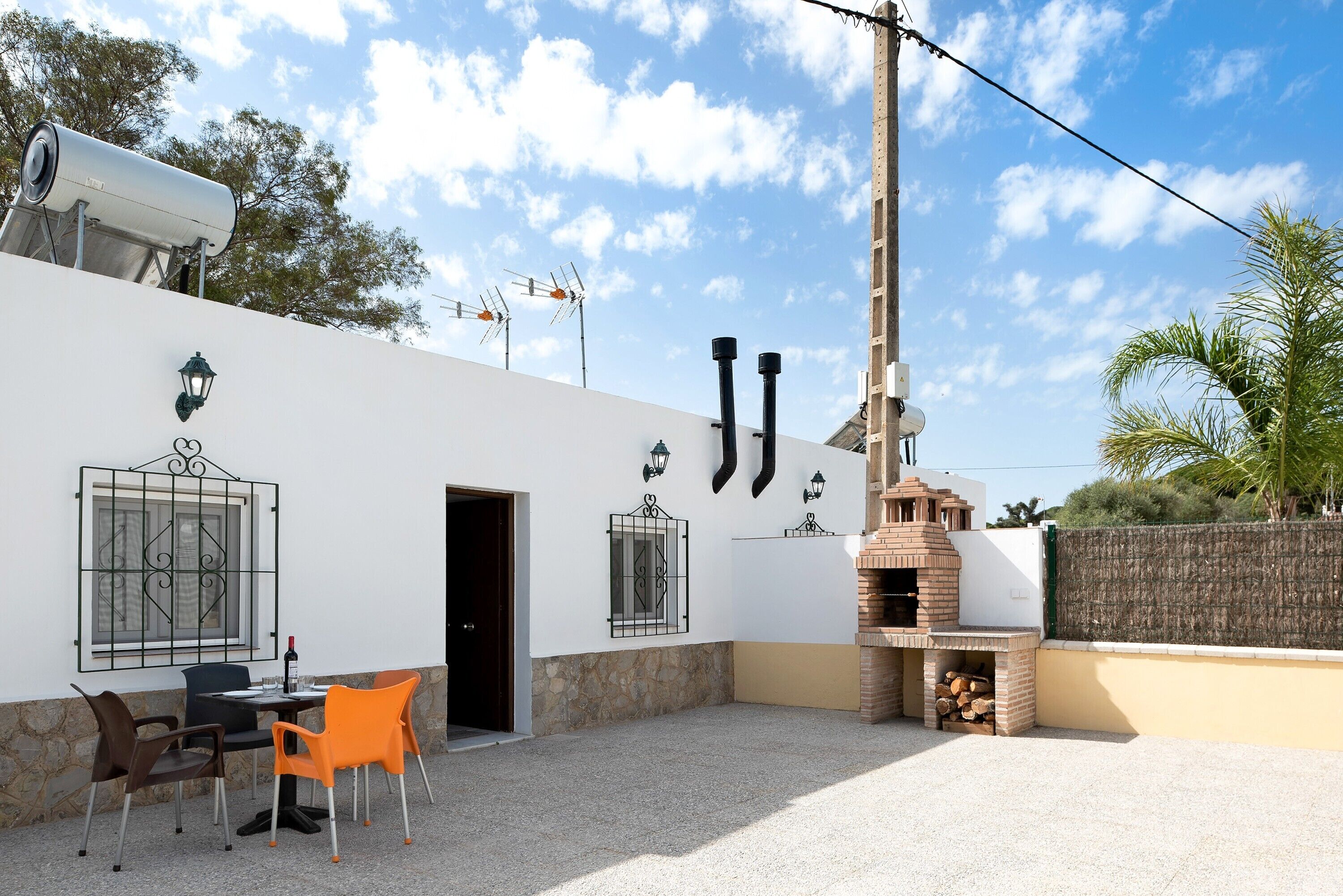 Un patio con posti a sedere all'aperto, un forno a mattoni e un muro in pietra.