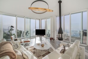 A spacious living room with a large TV, comfortable seating, and a view of the city. - Villa 'Crystal Ocean Villa' with Sea View, Heated Pool & Wi-Fi (EL SAUZAL)