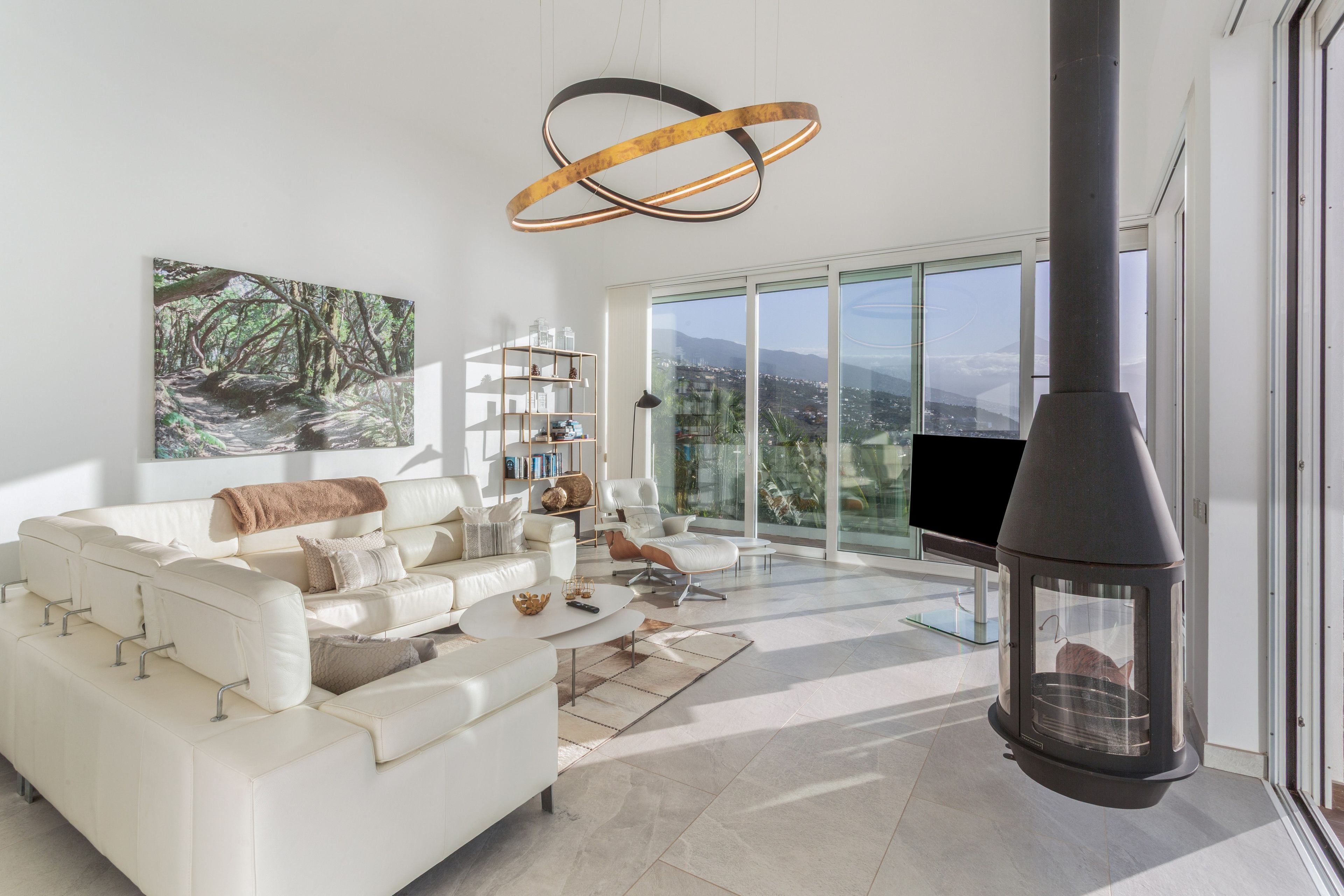 A modern living room with a white sofa, a coffee table, and a fireplace.