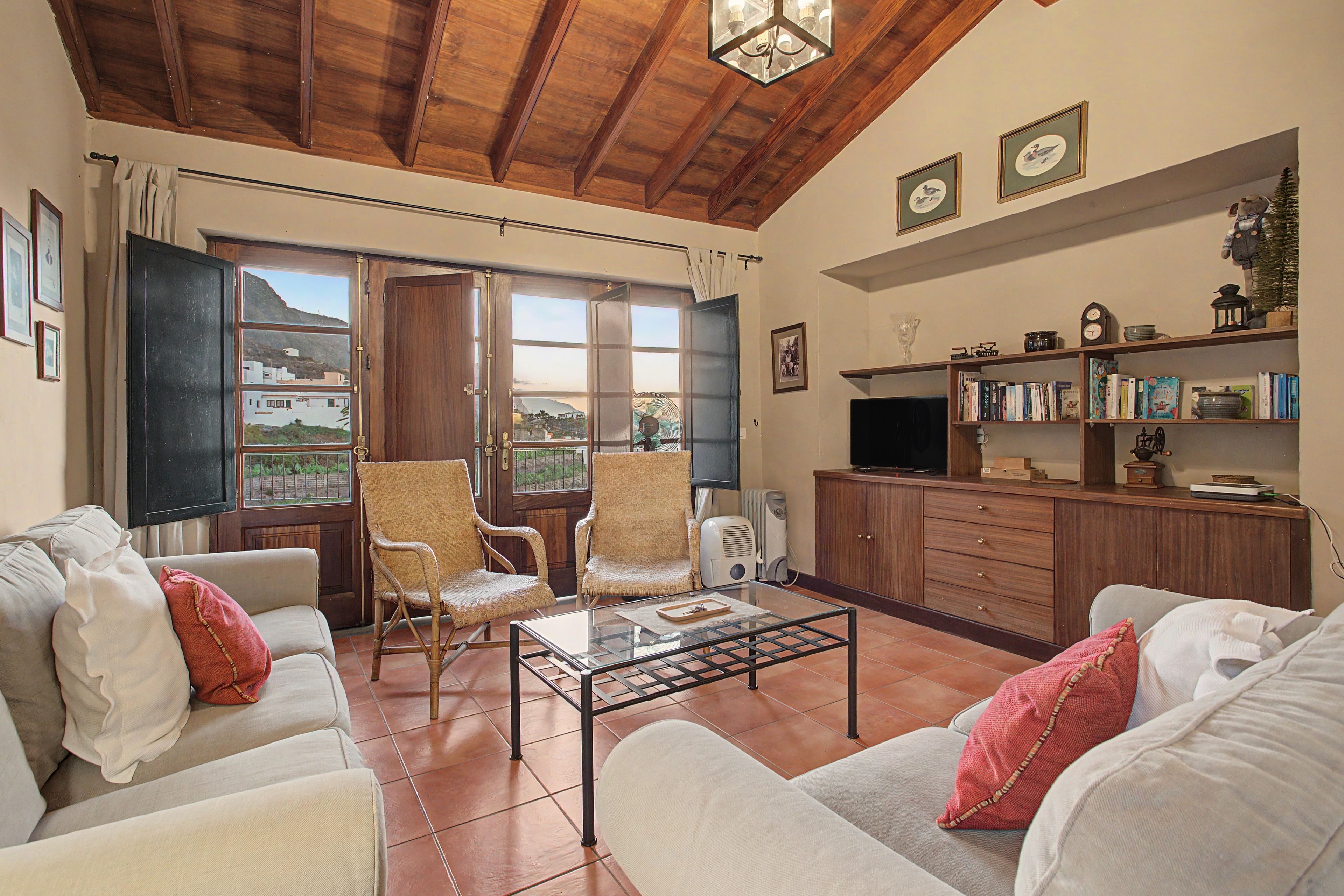 Una sala de estar con chimenea, televisor y estantería.
