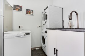 A compact laundry room with a washing machine, dryer, and a small cabinet with a sink. - Vacation Home "Villa Bahía de Michel" with Sea View, Pool, Garden & Wi-Fi (santa ursula)