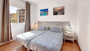 A bedroom with a bed, two nightstands, a window with curtains, and two wall-mounted pictures. - Holiday Home "Casa Roberto" with Private Balcony, Shared Pool and Wi-Fi (Candelaria)
