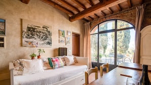 Una habitación acogedora con una cama, una mesa de comedor y un ventanal grande.