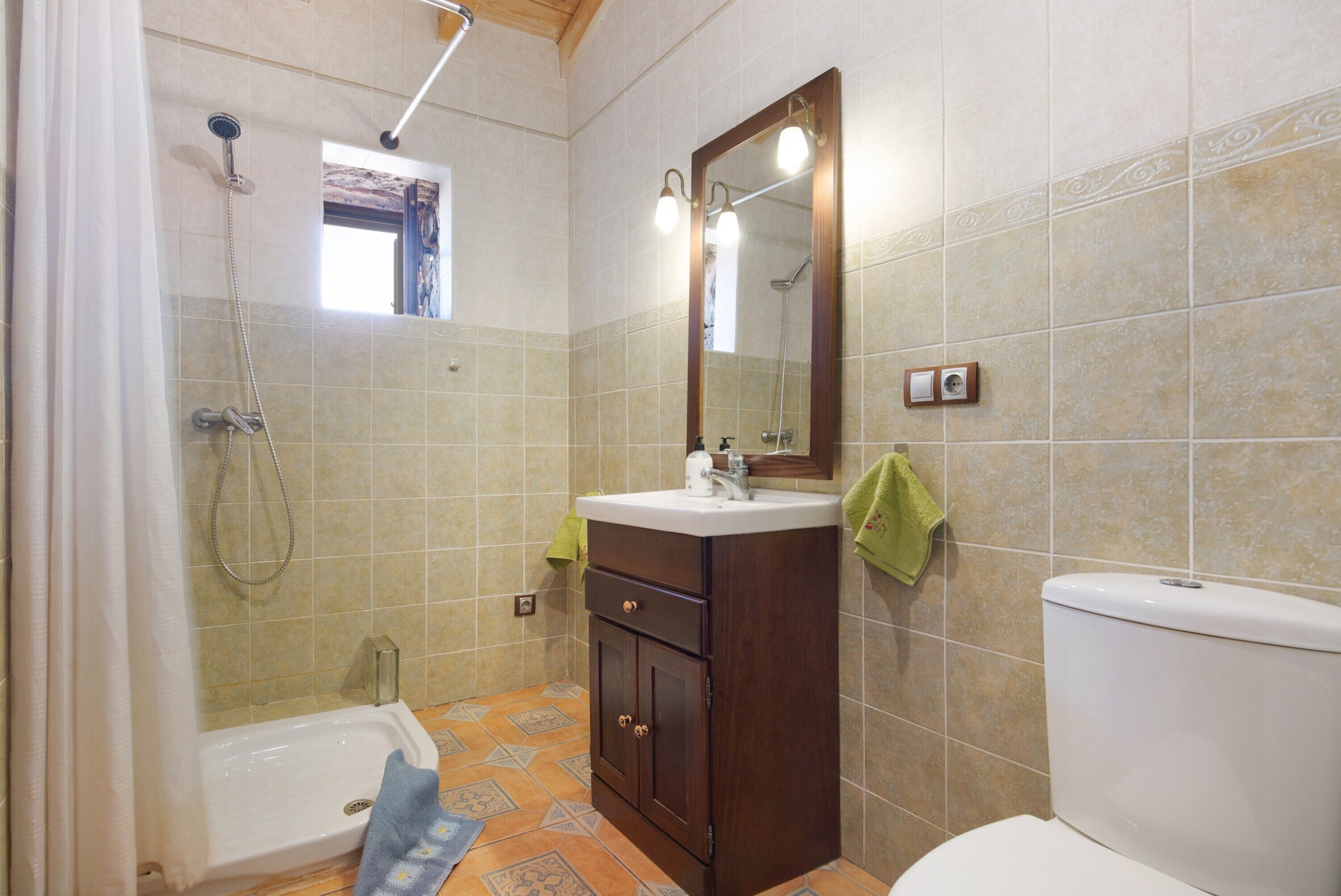 Un baño con bañera, lavamanos, inodoro y ducha.