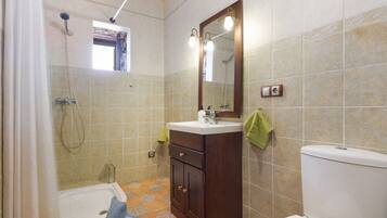 Un baño con bañera, lavamanos, inodoro y ducha.