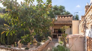 A courtyard with a stone pathway, cactus plants, and a building with a tiled roof. - Finca "Can Jeroni" with Private Terraces, Private Pool & Wi-Fi (Felanitx)