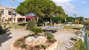 A residential area with a large tree, a hammock, a ping-pong table, and a playground. - Finca "Can Jeroni" with Private Terraces, Private Pool & Wi-Fi (Felanitx)