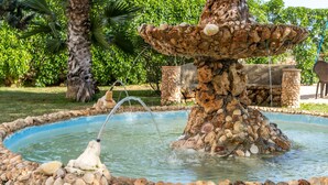A stone fountain with water spouting from its top, surrounded by a pool of water and a pebble border. - Finca "Can Jeroni" with Private Terraces, Private Pool & Wi-Fi (Felanitx)