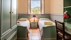 A bedroom with two beds, a window, a nightstand, a chair, and a vase of flowers. - Villa "Filippa" with Mountain View, Private Terrace & Private Garden (Nicosia)