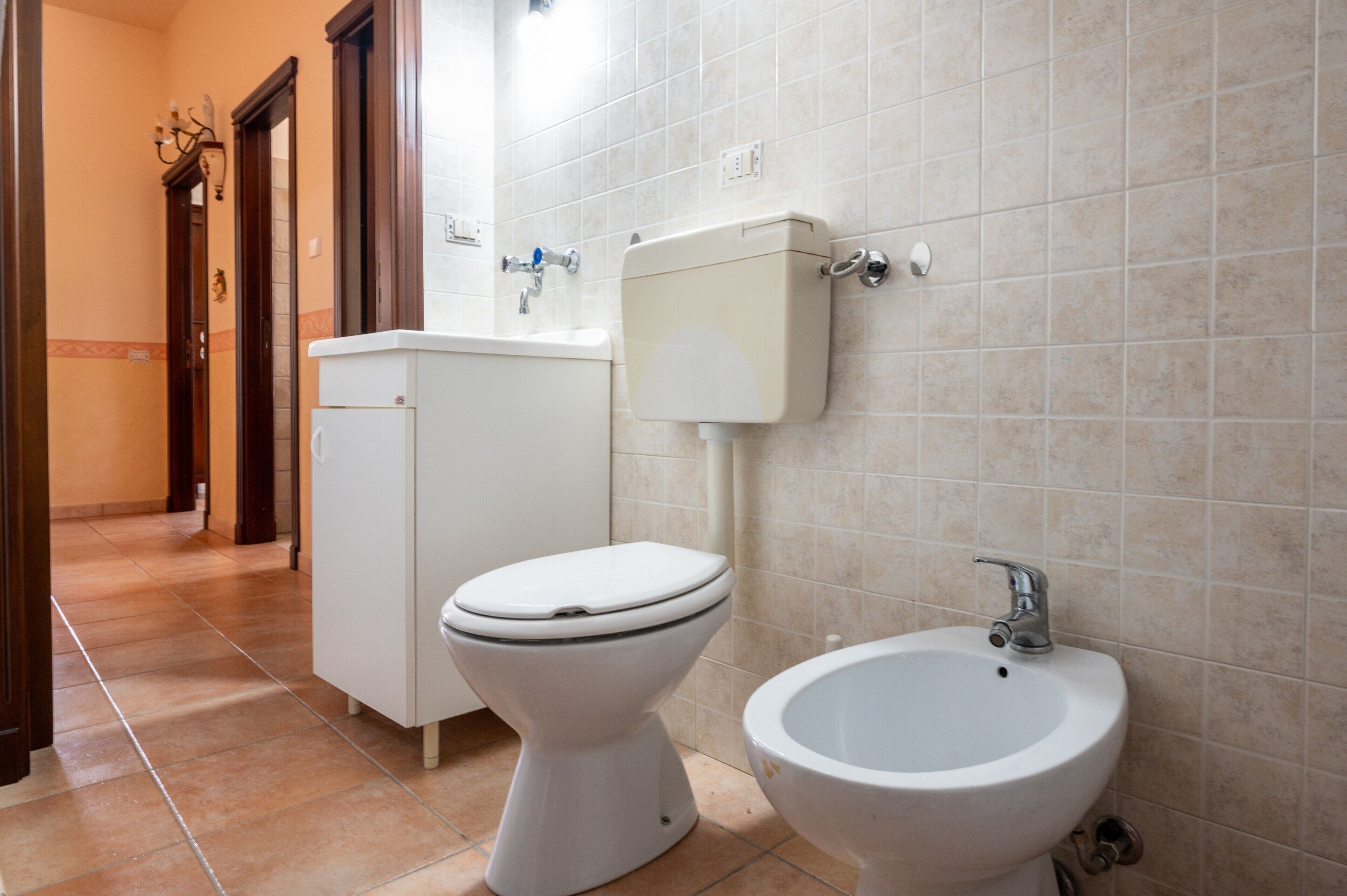 Un baño con inodoro, bidé y lavabo.