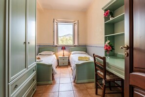 A bedroom with two beds, a window, a chair, and a wooden cabinet. - Villa "Filippa" with Mountain View, Private Terrace & Private Garden (Nicosia)