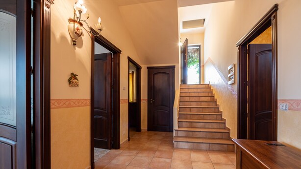 A hallway with a staircase, wooden doors, and a wall-mounted light fixture. - Villa "Filippa" with Mountain View, Private Terrace & Private Garden (Nicosia)