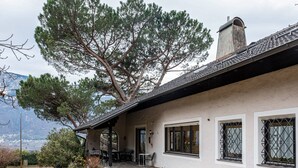 A house with a covered porch, a chimney, and a view of mountains.