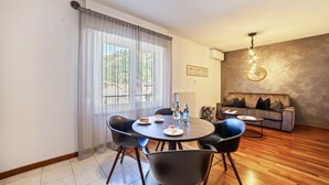 A dining area with a round table, chairs, and a sofa in a modern living space. - Holiday Apartment 'König - The King 4th' with Balcony & Wi-Fi (Meran)