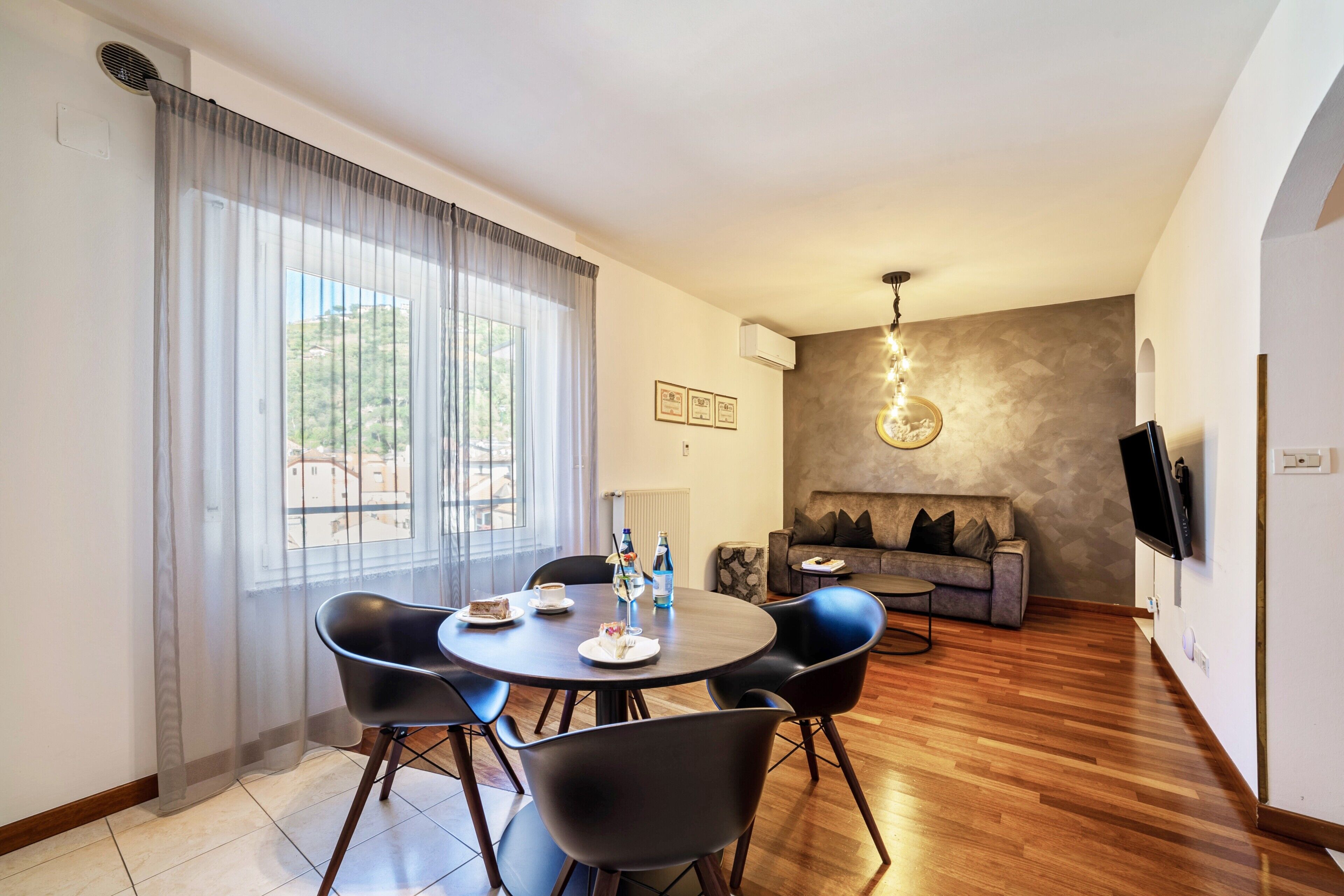 Un espace repas avec une table ronde, des chaises et un canapé en arrière-plan.