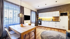 A modern kitchen with white cabinets, a microwave, and a coffee maker.