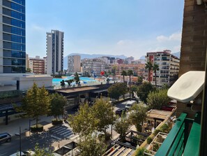 A view of a cityscape with modern buildings, a swimming pool, and a street with cars and trees. - Apartment “Casita Bonita” with Private Terrace, Shared Pool, and Wi-Fi (Calpe)