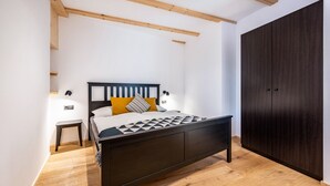 A bedroom with a bed, bedside tables, a wardrobe, and wooden flooring. - Holiday Apartment "Binderhof Apt Obm" with Mountain View, Private Terrace and Wi-Fi (Brixen)