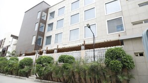 Un edificio de varios pisos con un diseño moderno, que presenta una combinación de ventanas rectangulares y cuadradas.