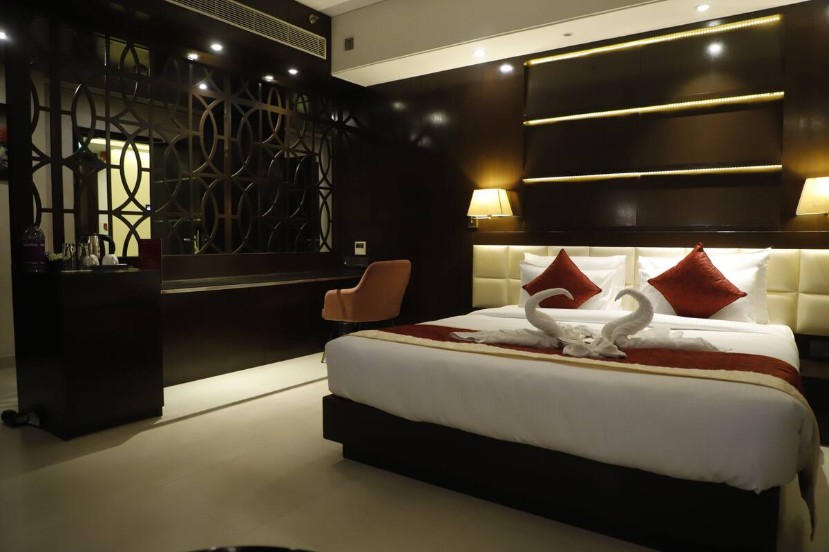 Una habitación de hotel moderna con una cama grande, un muro decorativo y un rincón de descanso.