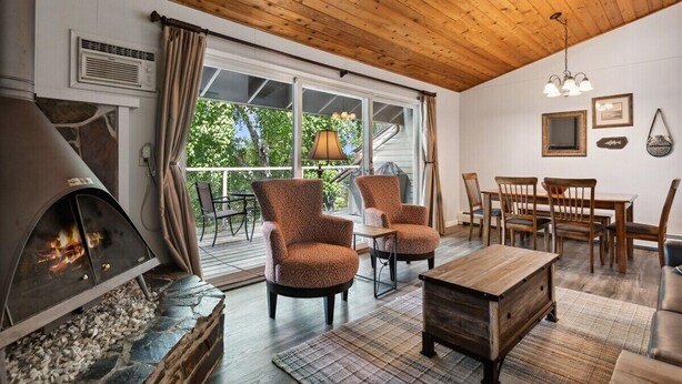 A cozy living room with a fireplace, wooden ceiling, and large windows. - Whitefish Lake Condo, 14BU, hillside! (Whitefish)