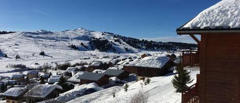 A snow-covered village with wooden buildings and a mountain in the background.