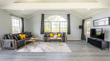 Cabaña de diseñador, hidromasaje, junto al lago | Área de sala de estar | Televisión de pantalla plana de 43 pulgadas con canales por cable