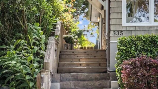 Un escalier en bois mène à une maison portant le numéro 335.