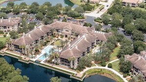 Vue aérienne d’un quartier résidentiel avec des maisons, un terrain de golf et une grande étendue d’eau.