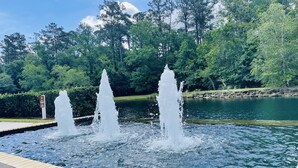 Une fontaine avec trois jets d’eau, située dans un parc.