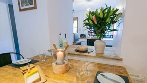 Een eettafel met een kaars, een brood, een glas water en een bord met bestek.