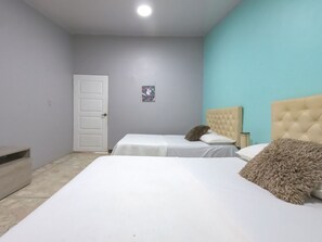 A bedroom with two beds, a door, and a small picture on the wall. - PB-T11 HABITACION DOBLE EN BARU CON WIFI (Cartagena)