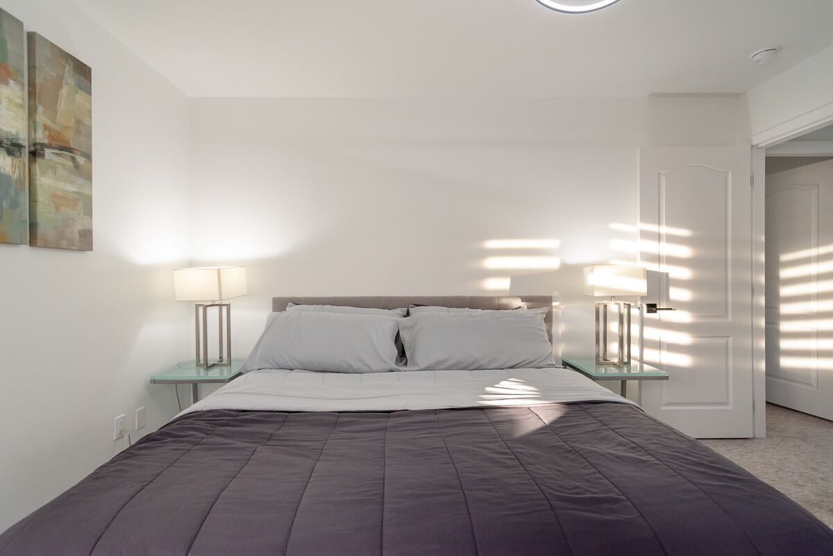 Ein modernes Schlafzimmer mit einem Bett, zwei Nachttischen und einem Schreibtisch.