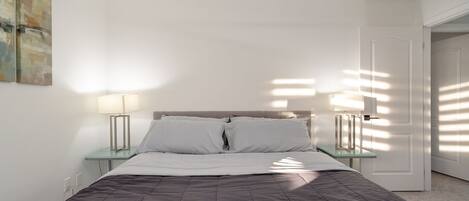 Ein modernes Schlafzimmer mit einem Bett, zwei Nachttischen und einem Schreibtisch.