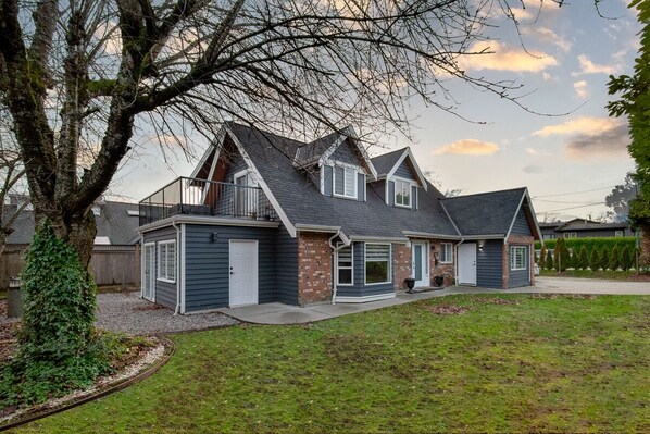 Une maison à deux étages avec un porche abrité, un garage et une pelouse bien entretenue.