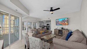 A spacious living area with a sofa, armchairs, a coffee table, and a television. - Channel Views! 6 Bedroom Spacious Deluxe Condo (north myrtle beach)