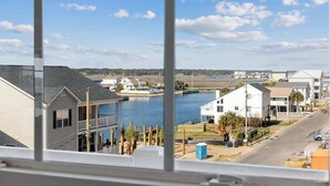 A residential area with houses, a dock, and a body of water. - Channel Views! 6 Bedroom Spacious Deluxe Condo (north myrtle beach)