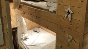Une chambre avec des lits superposés, des murs en bois, un petit bureau et une décoration en forme de cœur.