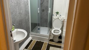Un bagno con doccia, WC e lavandino.