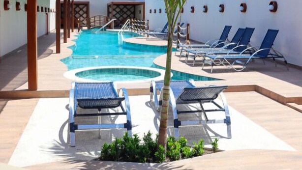 A pool area with multiple sun loungers and a palm tree. - BARRA DE MARAGOGI (Maragogi)