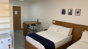 A hotel room with a wooden bed, a desk with two chairs, and a white wardrobe. - BARRA DE MARAGOGI (Maragogi)