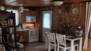 Un interior de cabaña acogedor con comedor, cocina y sala de estar.