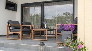 A modern outdoor seating area with two chairs and a table, a lantern, and flower planters. - Stunning home in Labin (Labin)