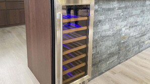 A wine refrigerator with a glass door, built into a kitchen counter with a stone backsplash. - 3 bedroom cozy home in Gotlands Tofta (Gotlands Tofta)