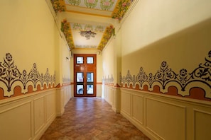 A hallway with ornate wall decorations and a wooden door at the end. - Casa Cosi - Don Bajos (Barcelona)