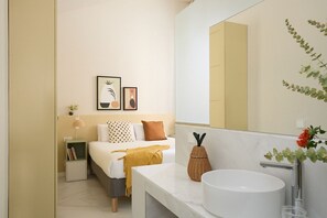 A modern bedroom with a bed, bedside table, and a large mirror. - Casa Cosi - Don Bajos (Barcelona)