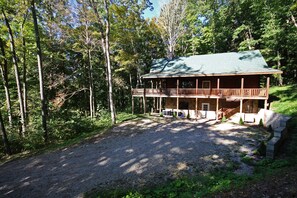 A two-story log cabin with a balcony, surrounded by a forest. - Rocky View Lodge - Private Lodge in Hocking Hills (Laurelville)