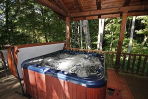 A hot tub on a wooden deck with a wooden railing and trees in the background. - Rocky View Lodge - Private Lodge in Hocking Hills (Laurelville)