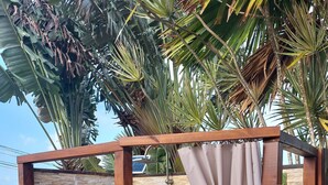 Una terraza de madera con una estructura de cabaña, una zona de ducha y un inodoro.
